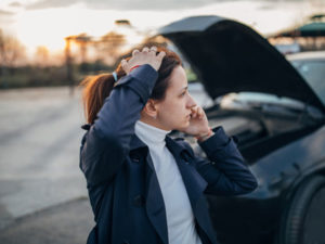 a distressed woman speaks on her phone after a car accident