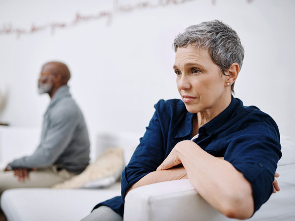 a divorced couple sit in a room at distance